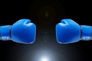 Bright blue boxing gloves representing wills versus trusts